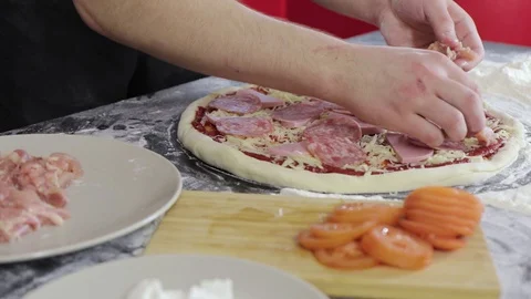 Hands of man put chicken breast on pizza dough close up 動画素材 128048026