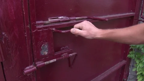 The hands of the man put a padlock on the gate. Close up. Vídeo Stock 104109377