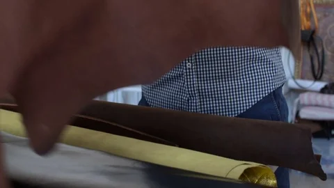 Hands of а man rolled up pieces of leather in a roll Stock Footage 72962353