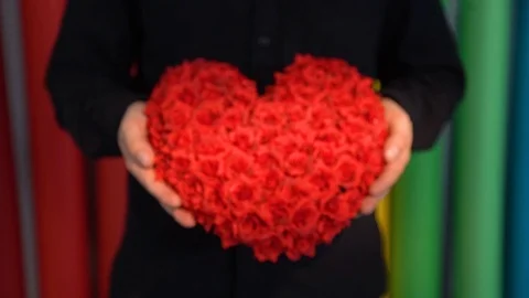 Hands of a man showing a gift: red velvet heart Stock Footage 102702496