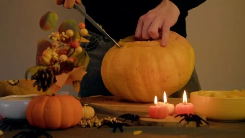 Hands of man skillfully cut thick slice from pumpkin, scene decorated with Stock Footage 318938675