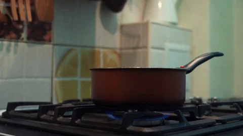 Hands of man stirs meal preparing in pot on stove in kitchen Stock Footage 83086546
