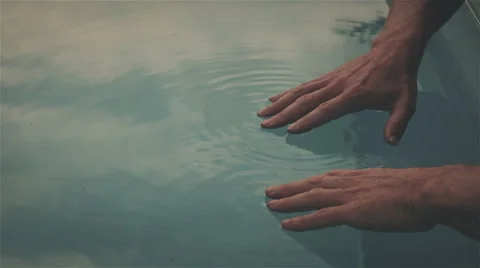 Hands on man on surface of swimmingpool, graded Stock Footage 57362213