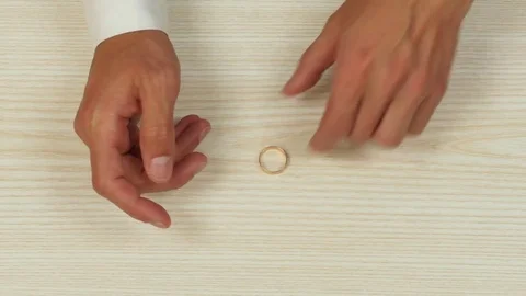 Hands of a man taking a ring off his finger. Top view Stock-Footage 77010764
