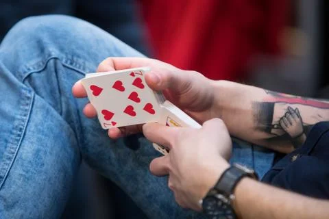 Hands of a man with a tattoo shuffles a deck of cards Stock Photos