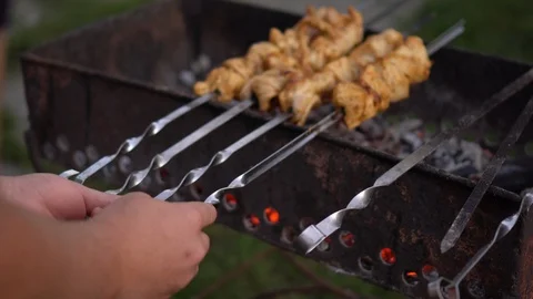Hands of man turn meat over skewers Video stock 93670191