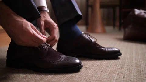 Hands of man tying shoelaces before going out Stock Footage 148678654
