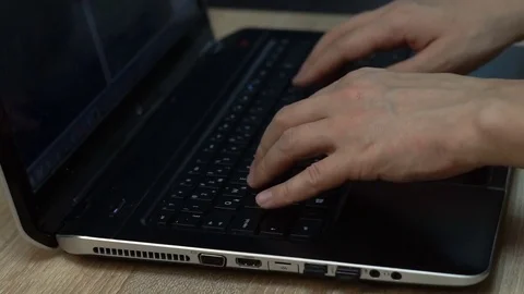 Hands of man typing on the laptop keyboard. Closeup. The laptop on the table Video stock 84592874