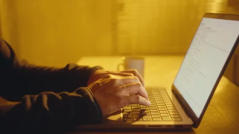 Hands of Man Typing on Laptop in Office with Yellow Light Stock Footage 257513201