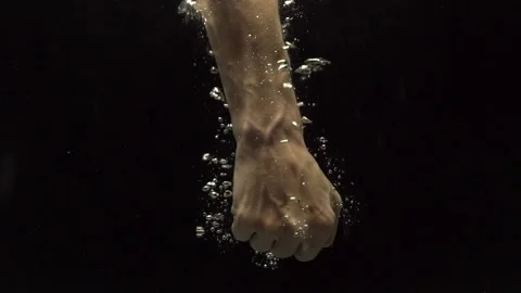 Hands of a man under water. Air bubbles on a black background. Stock Footage 152018570