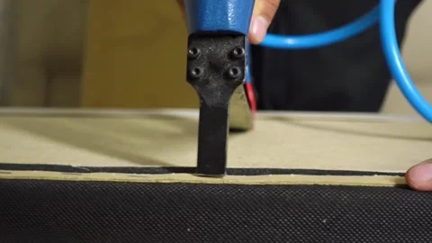 Hands of man upholster part of the bed with new fabric using a furniture stapler 動画素材 168643628