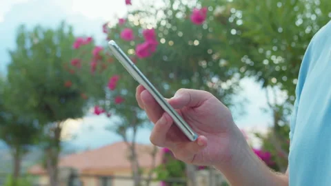 Hands of a man using a mobile phone. A man browsing an app on his mobile phone Stock Footage 311582173
