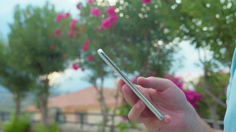 Hands of a man using a mobile phone. A man browsing an app on his mobile phone Stock Footage 312886061