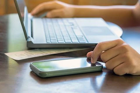 Hands of man using mobile smart phone and laptop with internet. Technology .. Stock Photos