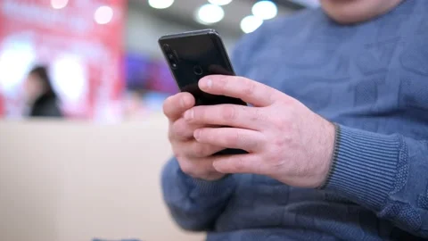 Hands of man using smartphone in the street near shopping mall. Communication Stock Footage 234808320