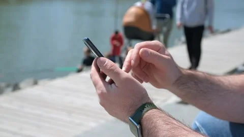Hands of man using smartphone in the street. Close-up view of male hands holding Stock Footage 253806955