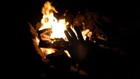 Hands of man warming up by camp fire. silhouette of hands at night Stock Footage 115014866