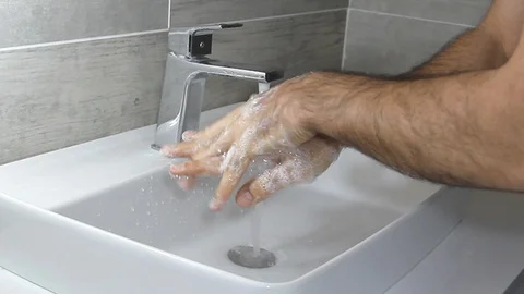 Hands of man wash their hands in a sink with foam to wash the skin Stock Footage 127856562
