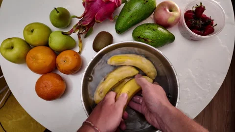 Hands of a man wearing an apron, standing in front of a table with fruit and Stock Footage 317372239