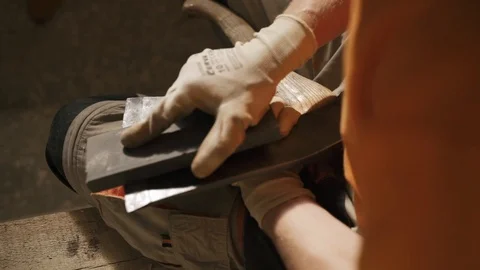 Hands of a man who is sharpening an ax blade Stock Footage 116767592