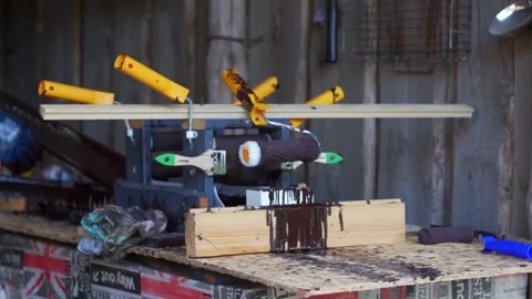 Hands of man in work gloves using homemade paint tool made of rollers and Stock Footage 166365228