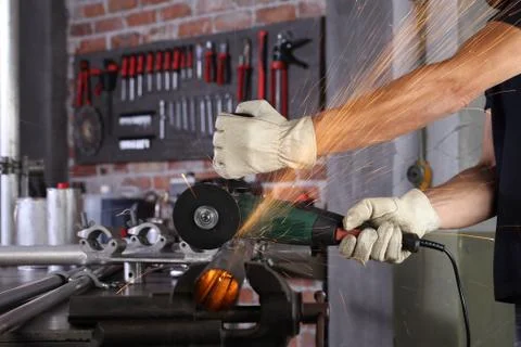 Hands man work in home workshop garage cut metal pipe, with construction glov Stock Photos