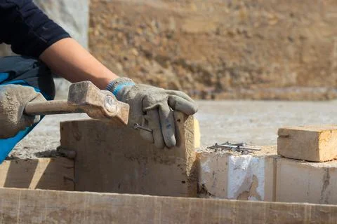 Hands of man working in construction site nailing in the wood with a hammer Foto stock