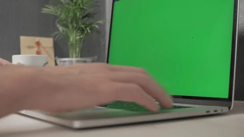 Hands of a man working on a laptop with green screen Stock Footage 120594838
