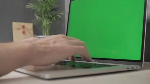 Hands of a man working on a laptop with green screen Stock Footage 120594842