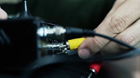 Hands of a Man Working with RCA Cables on a Decoder in His Living Room - 4K 動画素材 285335785
