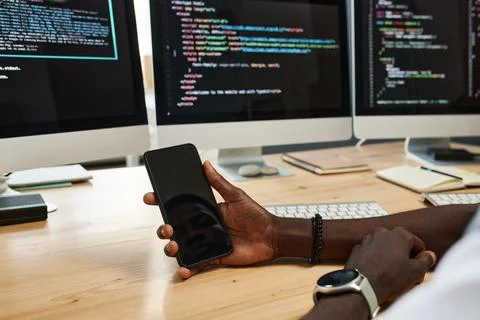 Hands of manager holding smartphone with reflection of his face on blank screen Foto stock