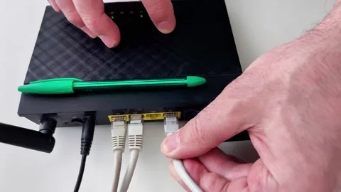 Hands Managing Router Cables and Buttons for Network Setup Stock Footage 330631859