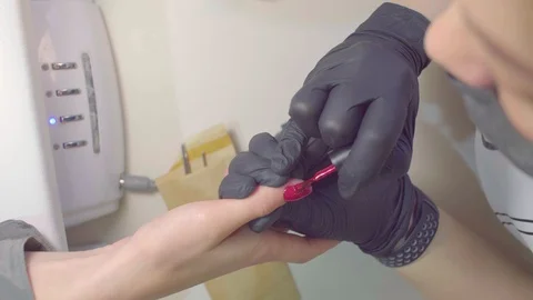 Hands of manicurist applies shellac to the client Stock Footage 102750215
