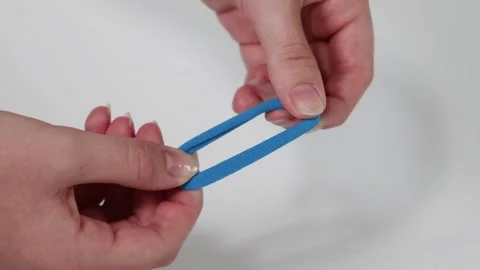 Hands Manipulating Blue Elastic Band Close-Up Stock Footage 311037493