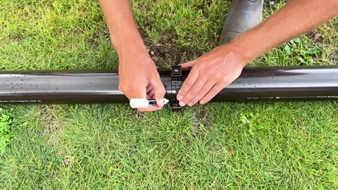 Hands Marking Plastic Downspout Pipe with Marker for Installation Stock Footage 342889702