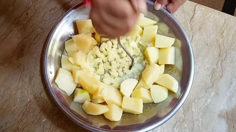 Hands Mashing Boiled Potato Chunks in Metal Plate, Cooking Prep, Stock Footage 329094846