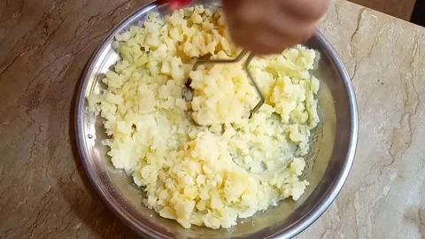 Hands Mashing Boiled Potato Chunks in Metal Plate, Cooking Prep, Video stock 329094849