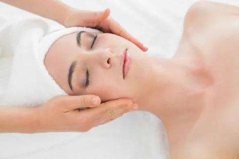 Hands massaging woman's face at beauty spa Stock Photos