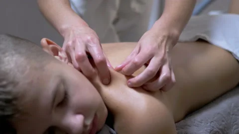 Hands of the Masseur are Massaging Back of a Teenager, a Child in a Spa Salon Vídeos de archivo 167186314