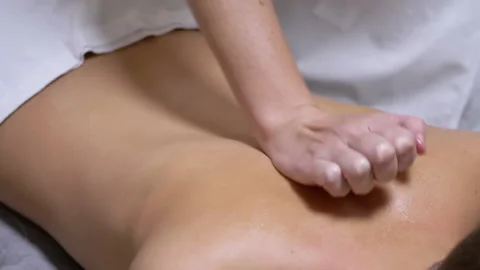 Hands of the Masseur are Massaging Back of a Teenager, a Child in a Spa Salon Stock-Footage 167425787