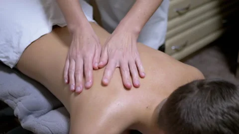 Hands of the Masseur are Massaging Back of a Teenager, a Child in a Spa Salon Stock Footage 167425874