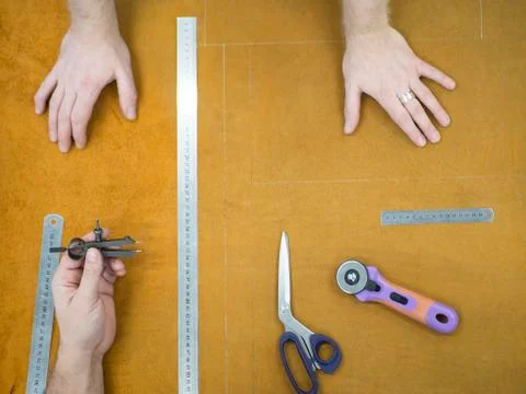 Hands of the master and studend. Marking leather for making bags, purses or Stock Photos