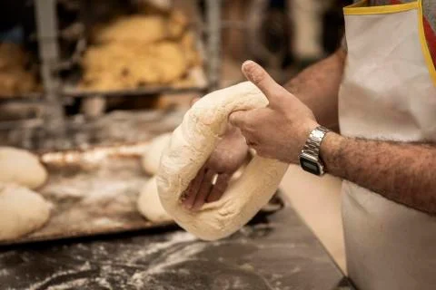Hands of the master baker in bread production Stock Photos