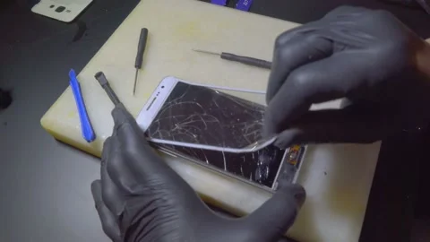 Hands of master changes glass in phone,replacing broken touch screen in phone. Video stock 106260717