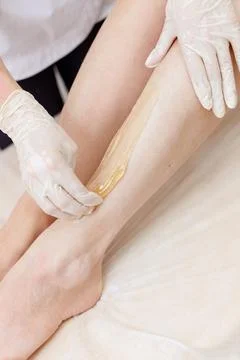 Hands of the master of depilation close-up apply the paste for shugaring on t Stock-Fotos