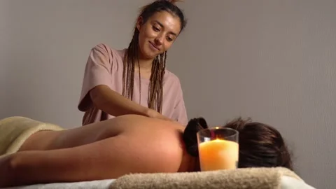 Hands of master of message massage back of woman lying on couch on table Stock Footage 221434663