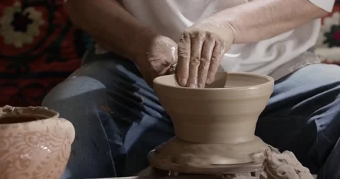 Hands of a master potter working on a potter's wheel in the manufacture of Stock Footage 242155237