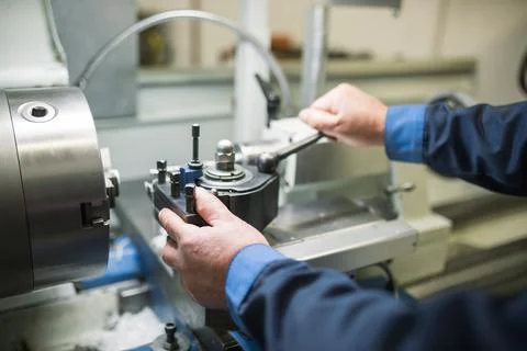 The hands of a master working behind a lathe metal machine Foto stock