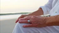 Hands Of Mature Couple Relaxing And Holding Hands On The Beach At Sunrise Stock Footage