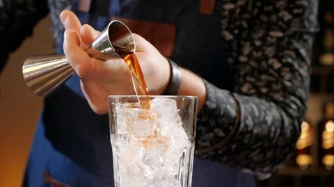 Hands measuring cocktail ingredient in jigger then pouring it in a glass 動画素材 105295537